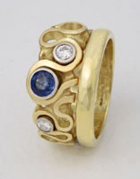 An asymmetrical 'Loop Ring' as an Engagement ring with blue Sapphire and diamonds together with wedding band